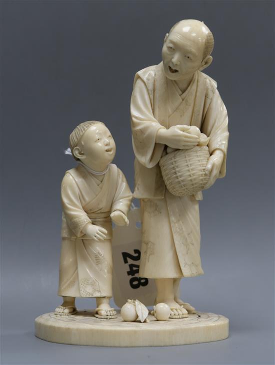 A Japanese ivory group of two figures with basket of oranges height 16cm